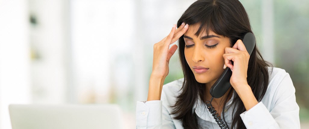 Girl talking on a phone and holding her head