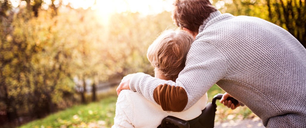 Man hugging woman in wheelchair