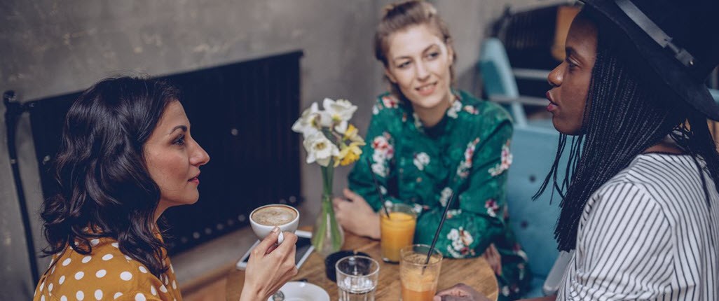 Woman talking with friends and drinking coffe